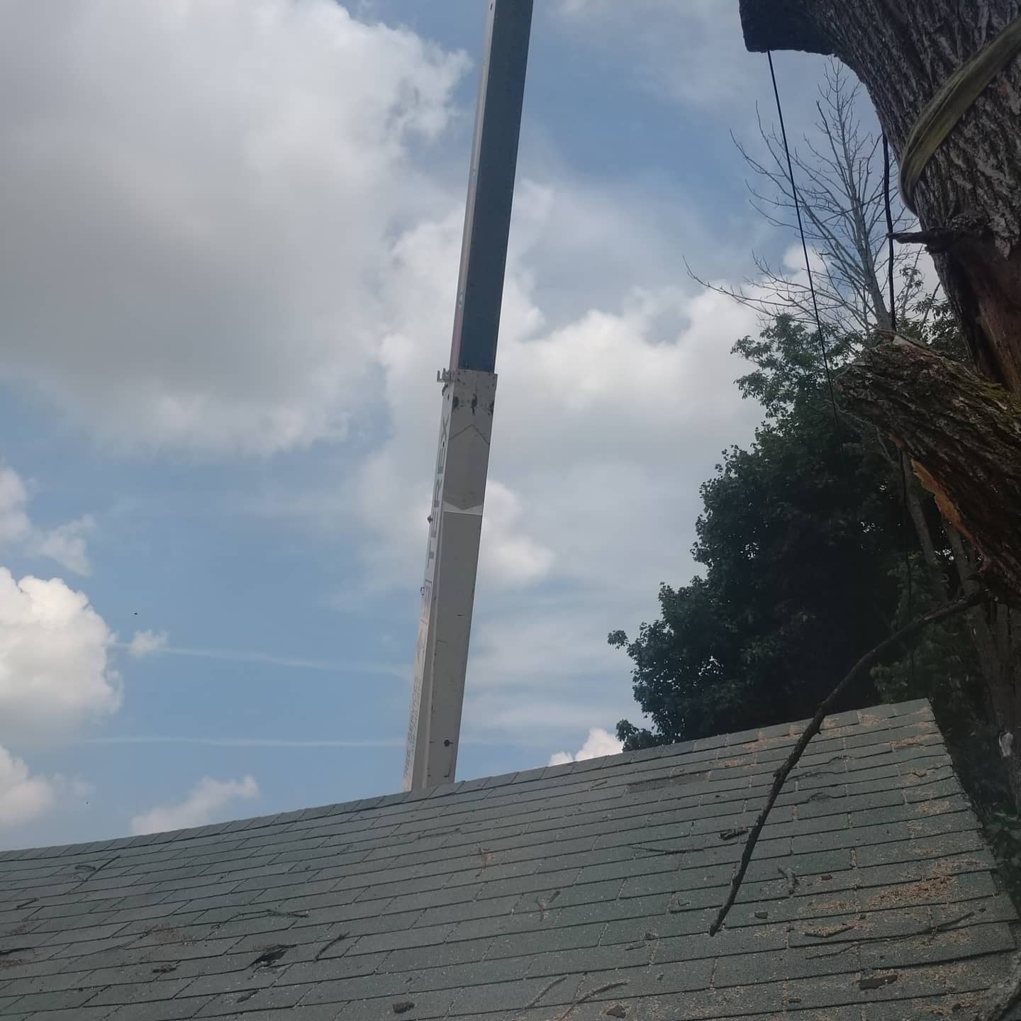 Crane boom positioned above a residential roof